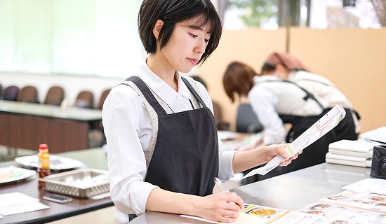 資料を片手に作業をするM・Iさん
