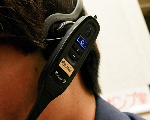 耳に電子機器をつけている男性
